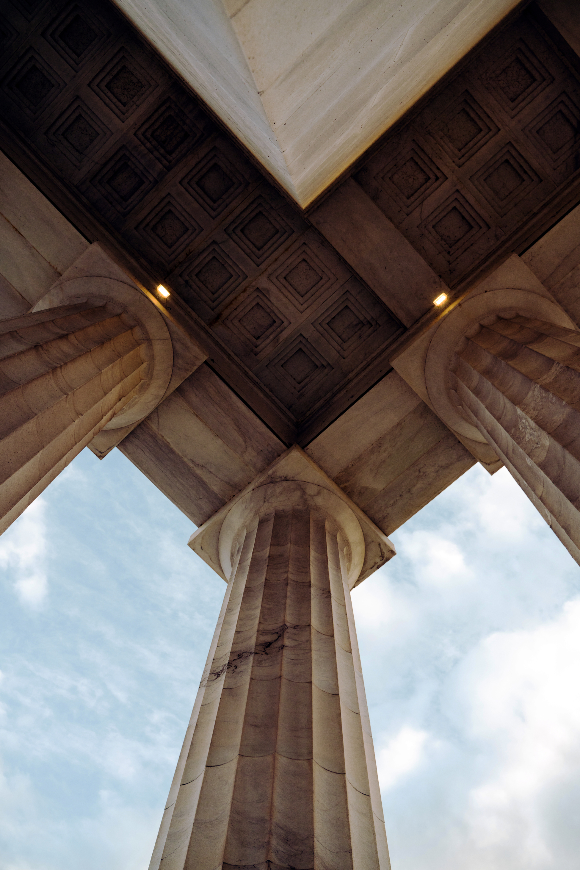 Stone columns supporting a civic structure, viewed from below